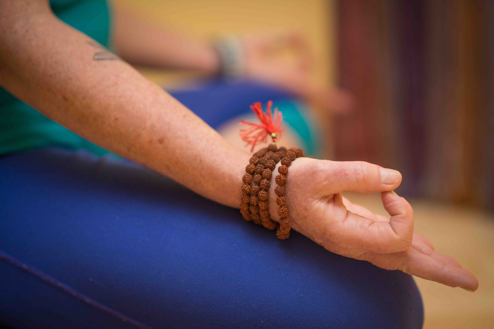 A woman's hands resting on her knees while meditating